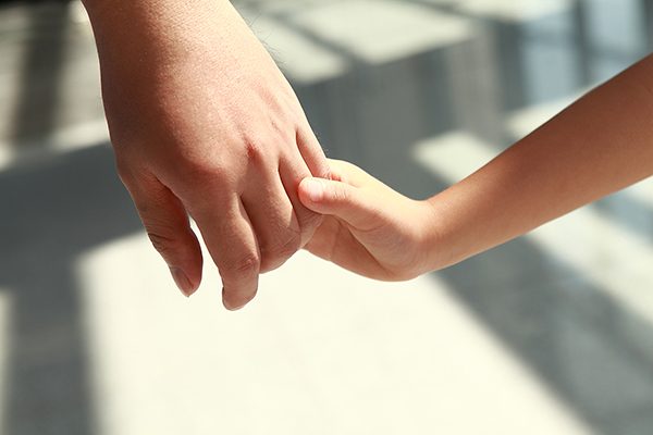 Close up of parent and child holding hands